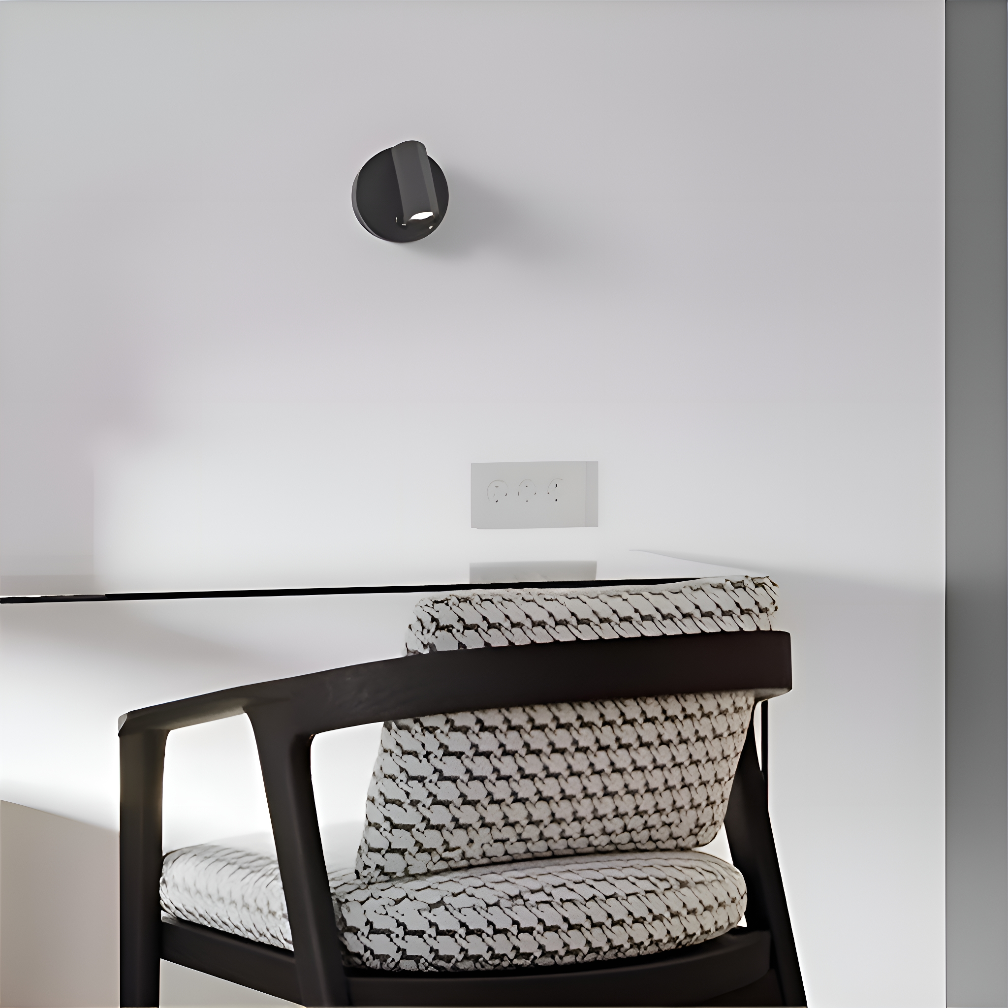 Stuhl mit gemustertem Sitz, Schreibtisch und Wandleuchte. Weiße Wand und Steckdose.