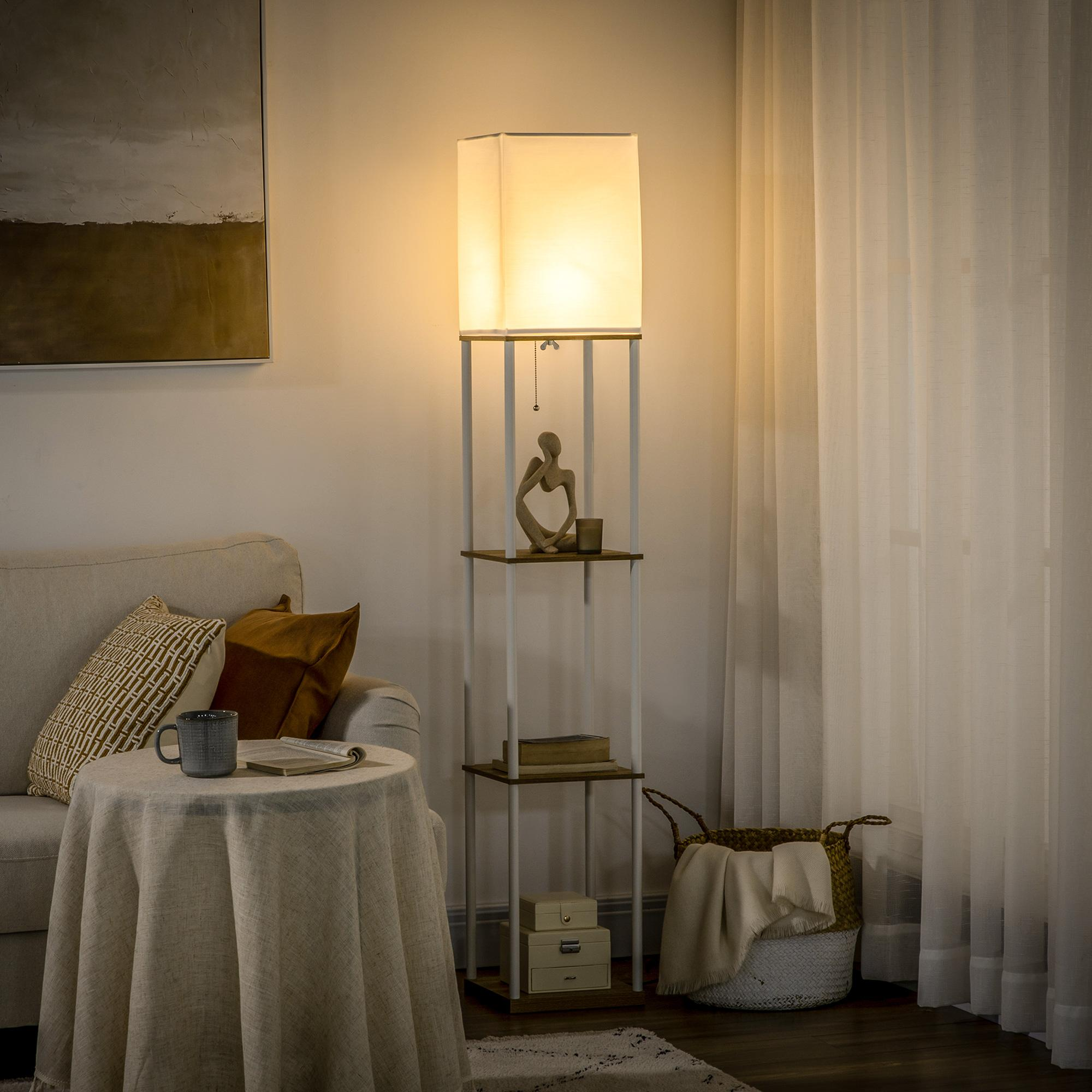 Lámpara de pie con estantes, mesa redonda con tela y sofá en una habitación.