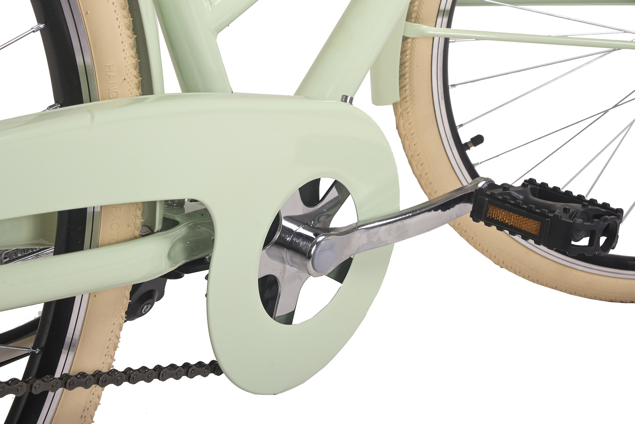 Nahaufnahme des Pedals eines mintgrünen Fahrrads. Kette, Pedal und Reifen sichtbar. Weißer Hintergrund.