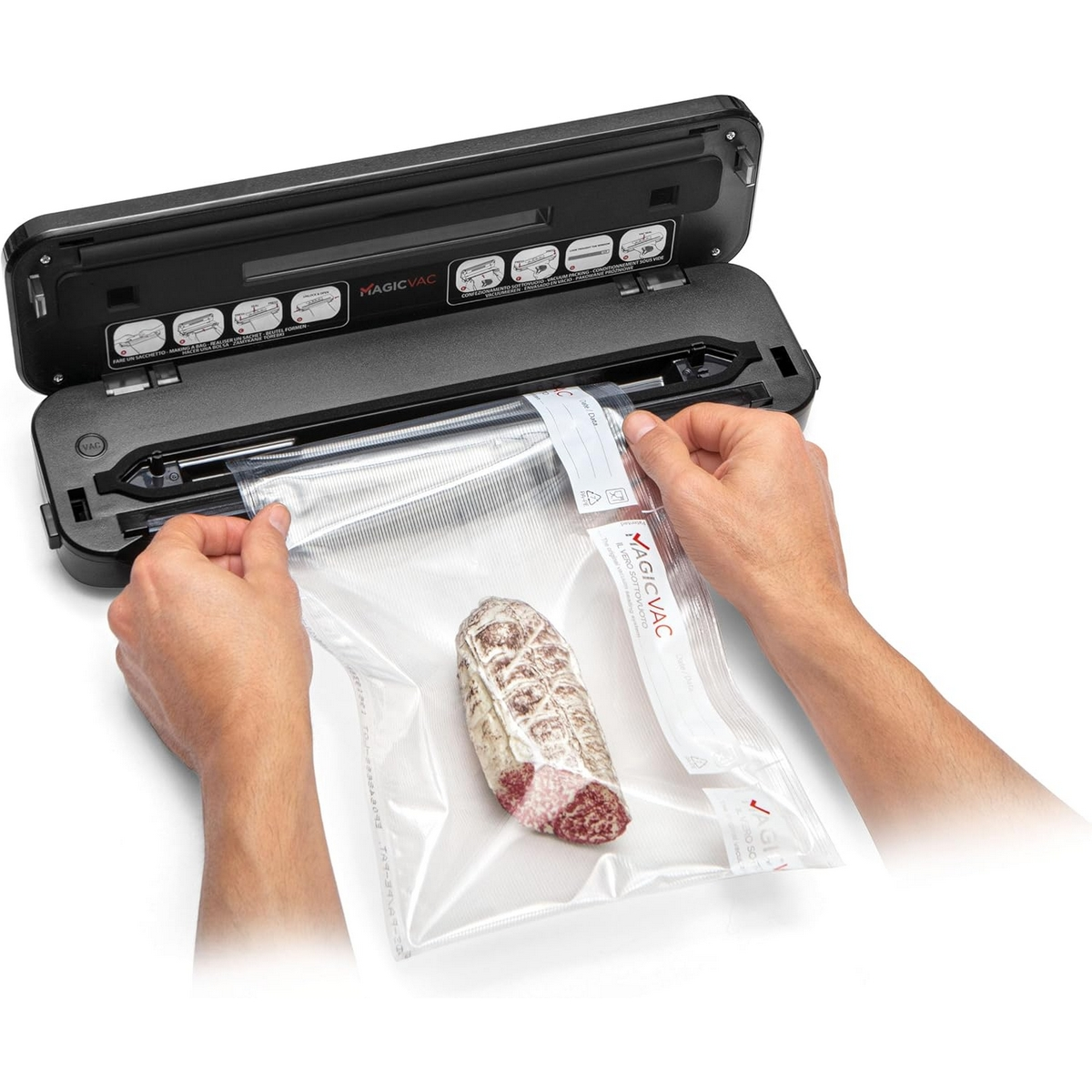 Urządzenie do pakowania próżniowego z salami w worku. Dwie ręce trzymają worek.