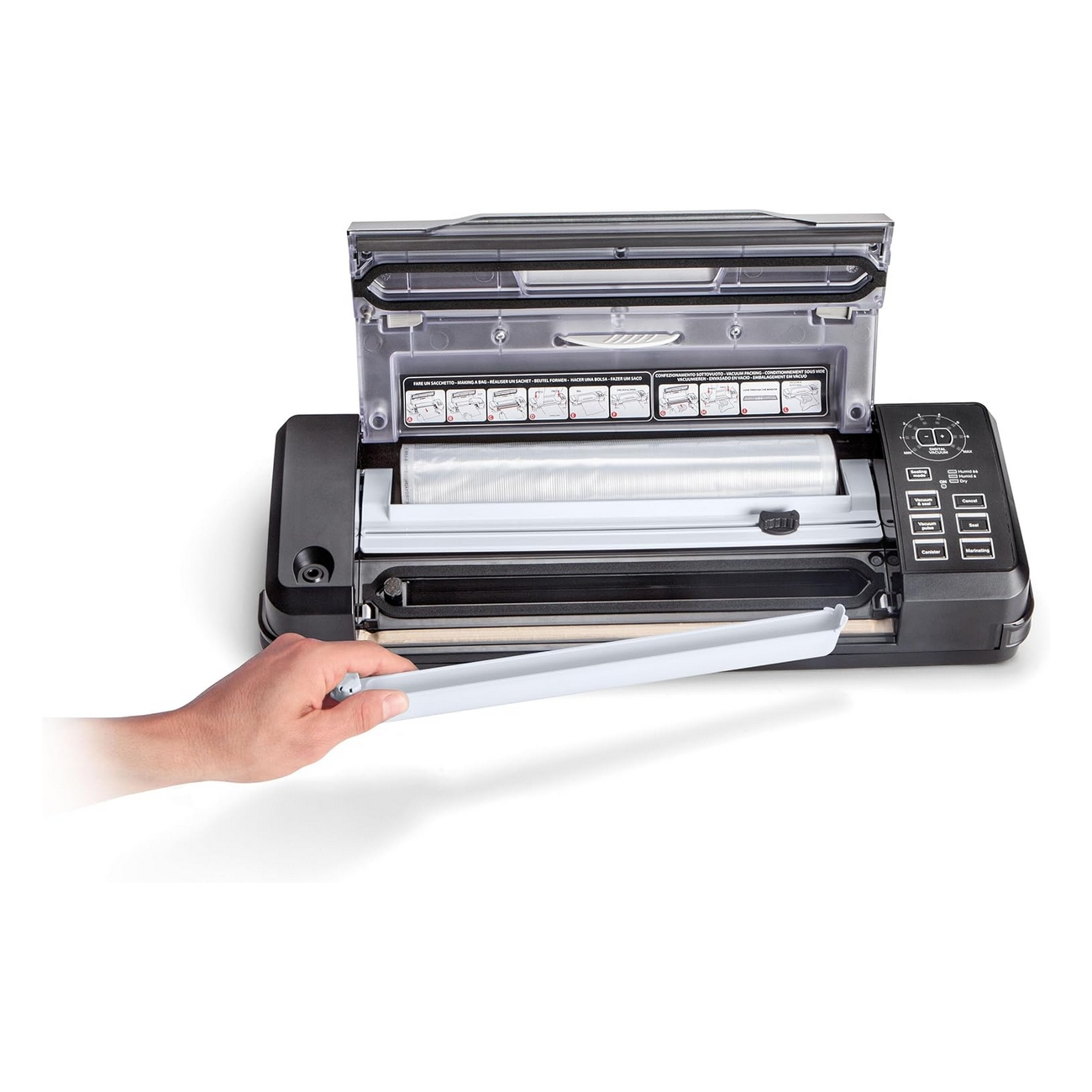 Czarno-szara zgrzewarka próżniowa. Pokrywa jest otwarta, a ręka trzyma tacę.