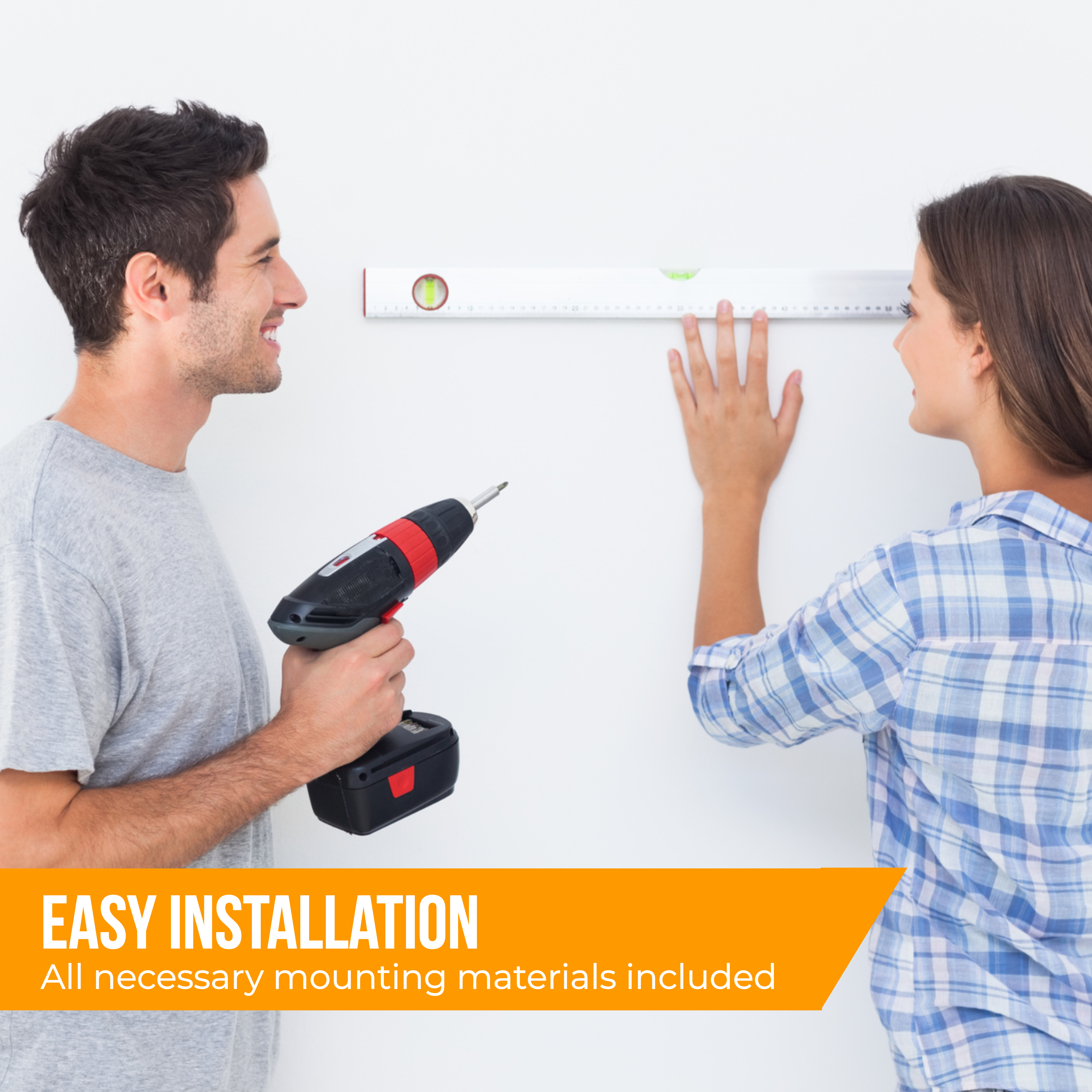 Mężczyzna i kobieta z wiertarką i poziomnicą instalują deskę na ścianie.