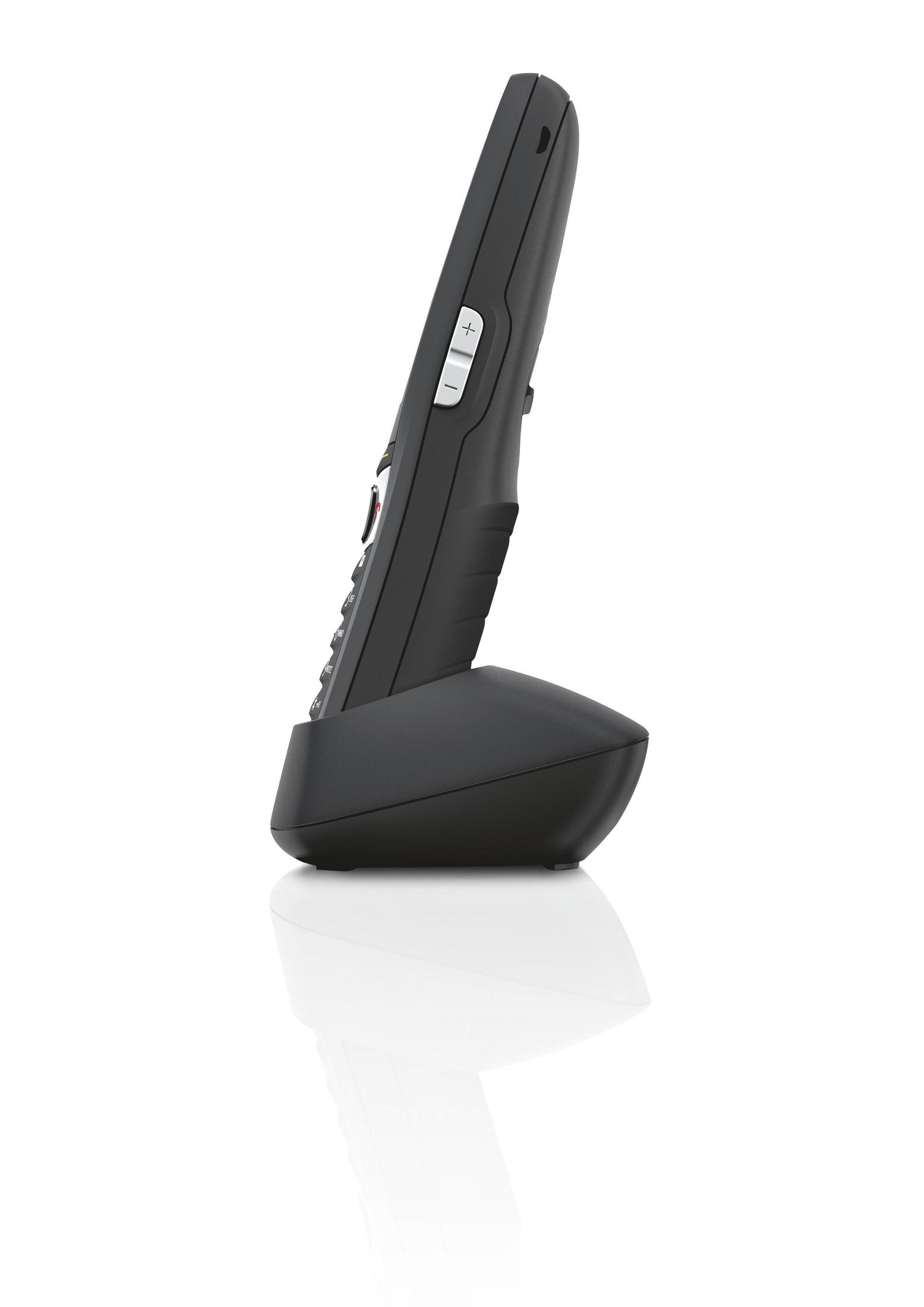 Ein schwarzes schnurloses Telefon auf einer schwarzen Basis. Das Telefon ist nach links abgewinkelt.