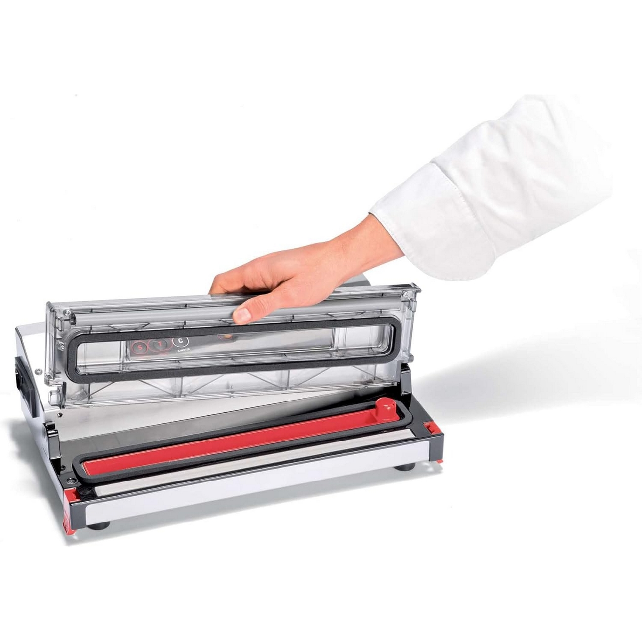 Ręka osoby zamyka górną część zgrzewarki próżniowej. Zgrzewarka jest srebrna i czerwona.