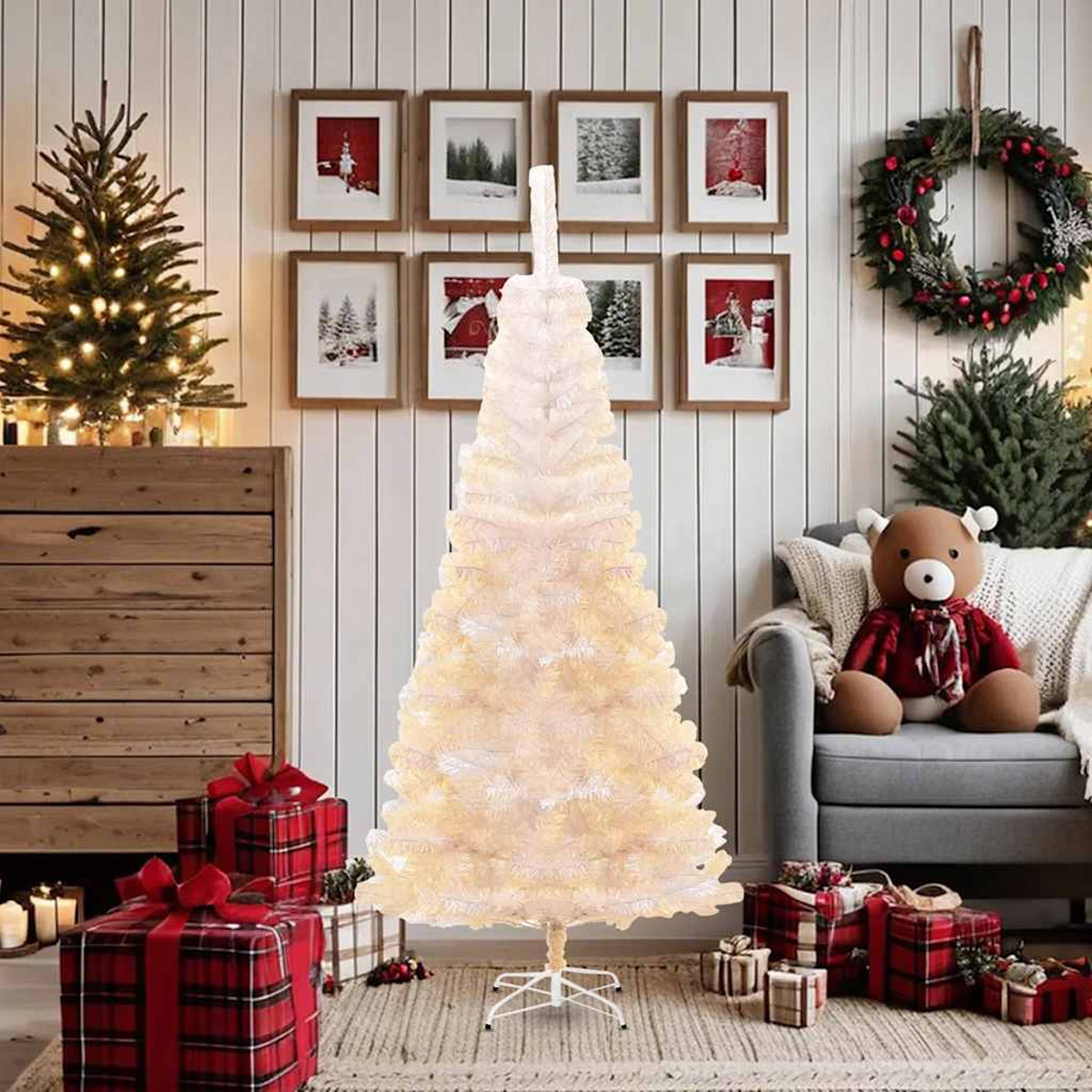 Ein weißer Weihnachtsbaum steht in einem Raum. Geschenke und Dekorationen umgeben ihn.