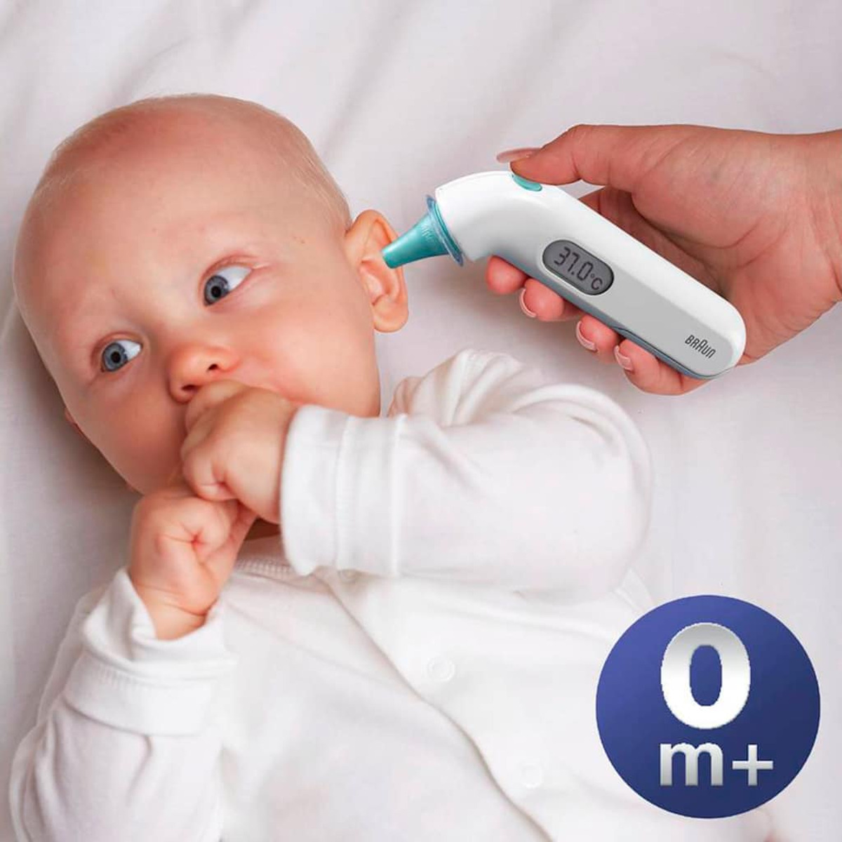 Dziecko, któremu mierzy się temperaturę termometrem Braun w uchu.