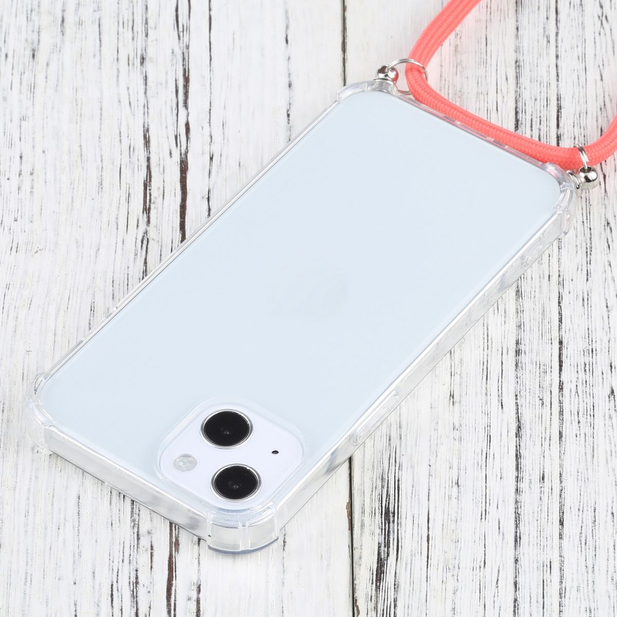 Ein Telefon in einer durchsichtigen Hülle mit rotem Band, auf Holzoberfläche.