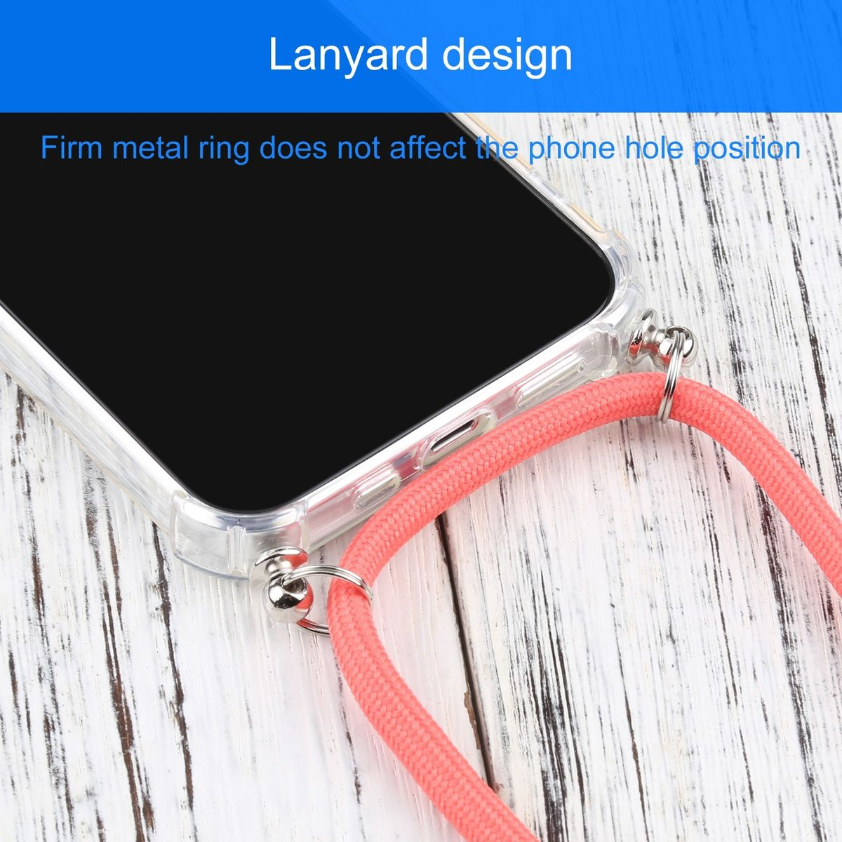 Ein Telefon in einer durchsichtigen Hülle mit einem rosa Riemen liegt auf einer weißen Holzoberfläche. Der Riemen hat einen Metallring.