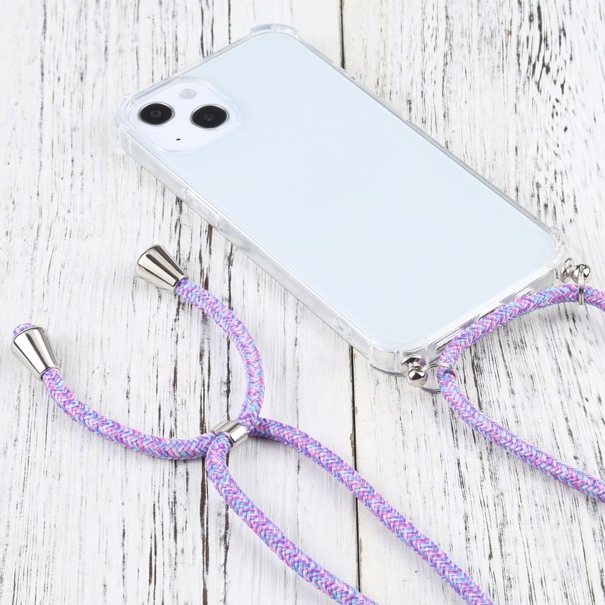 Transparente Handyhülle mit lila-pinkfarbenem Band. Das Telefon ist weiß. Hintergrund ist Holztisch.