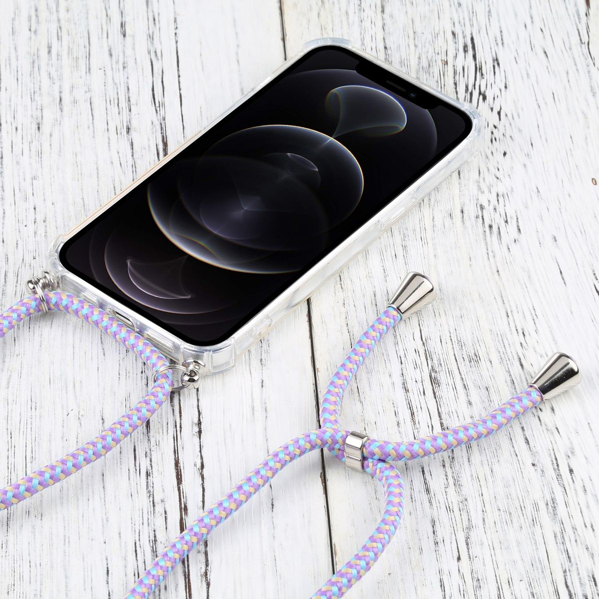 Telefon mit Lanyard, in einer durchsichtigen Hülle. Weiße Holzoberfläche. Hintergrund: Zeitschrift.