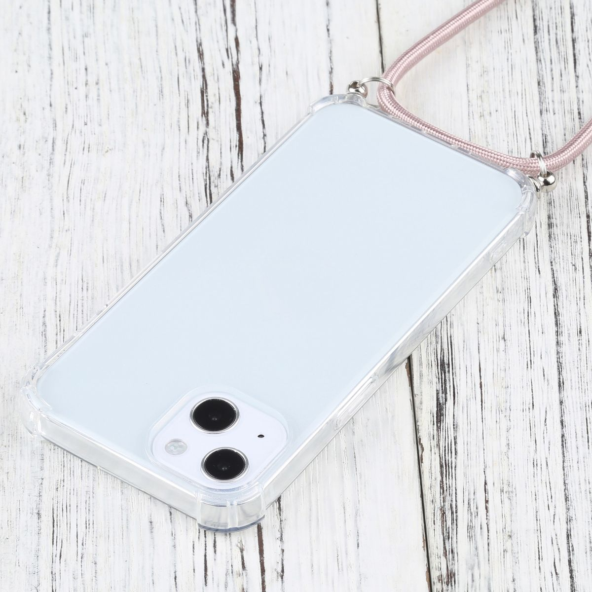 Ein Telefon mit einer transparenten Hülle und einem rosa Band, das auf einem Holztisch liegt. Das Telefon liegt nach oben.