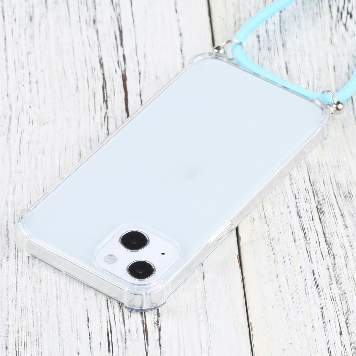 Transparente Handyhülle mit blauem Lanyard. Die Handyhülle liegt auf einer weißen Holzoberfläche.