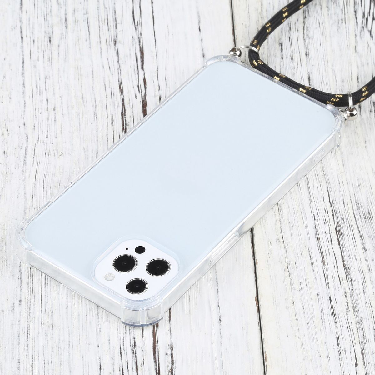 Telefon in klarer Hülle mit schwarzem und goldenem Nackengurt. Auf Holzoberfläche.