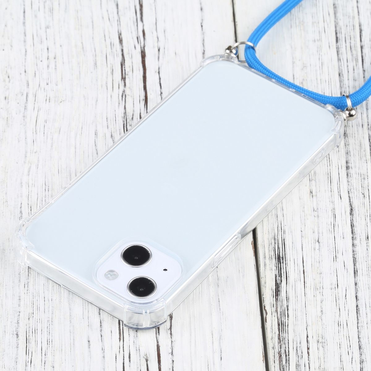 Ein Telefon in einer transparenten Hülle mit blauem Lanyard, das auf einer Holzoberfläche liegt. Telefon und Hülle sind transparent.