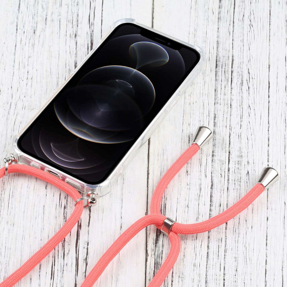 Ein Telefon in einer transparenten Hülle mit einem korallenroten Lanyard liegt auf Holz.