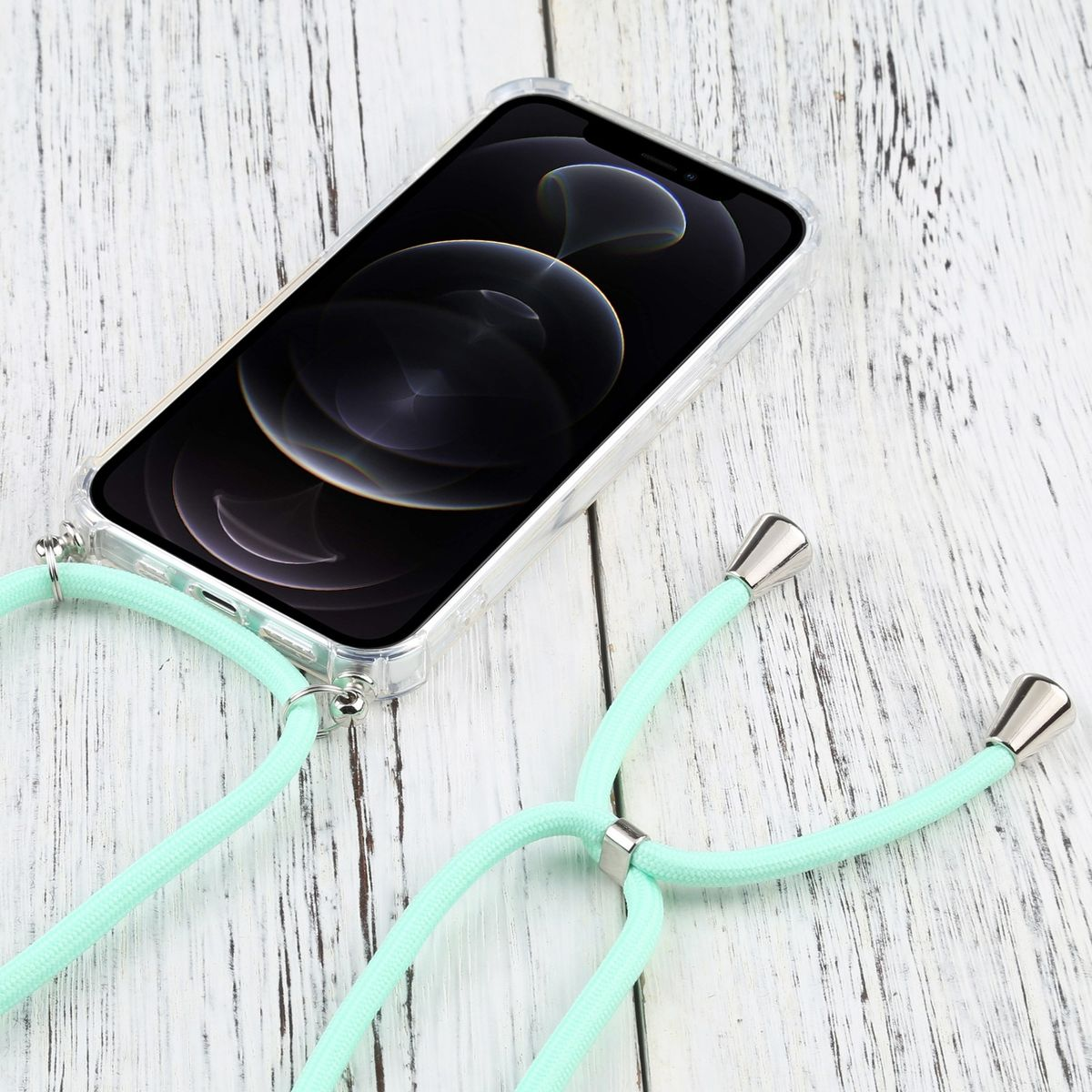 Telefon mit Lanyard und klarer Hülle auf Holzoberfläche. Lanyard ist hellgrün.