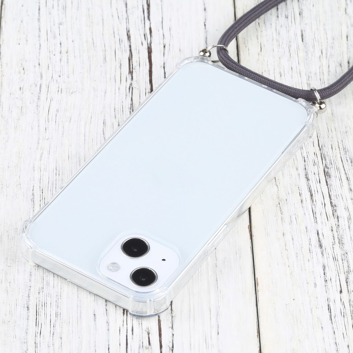 Telefon mit klarer Hülle und grauem Schlüsselband. Das Telefon liegt auf Holz.