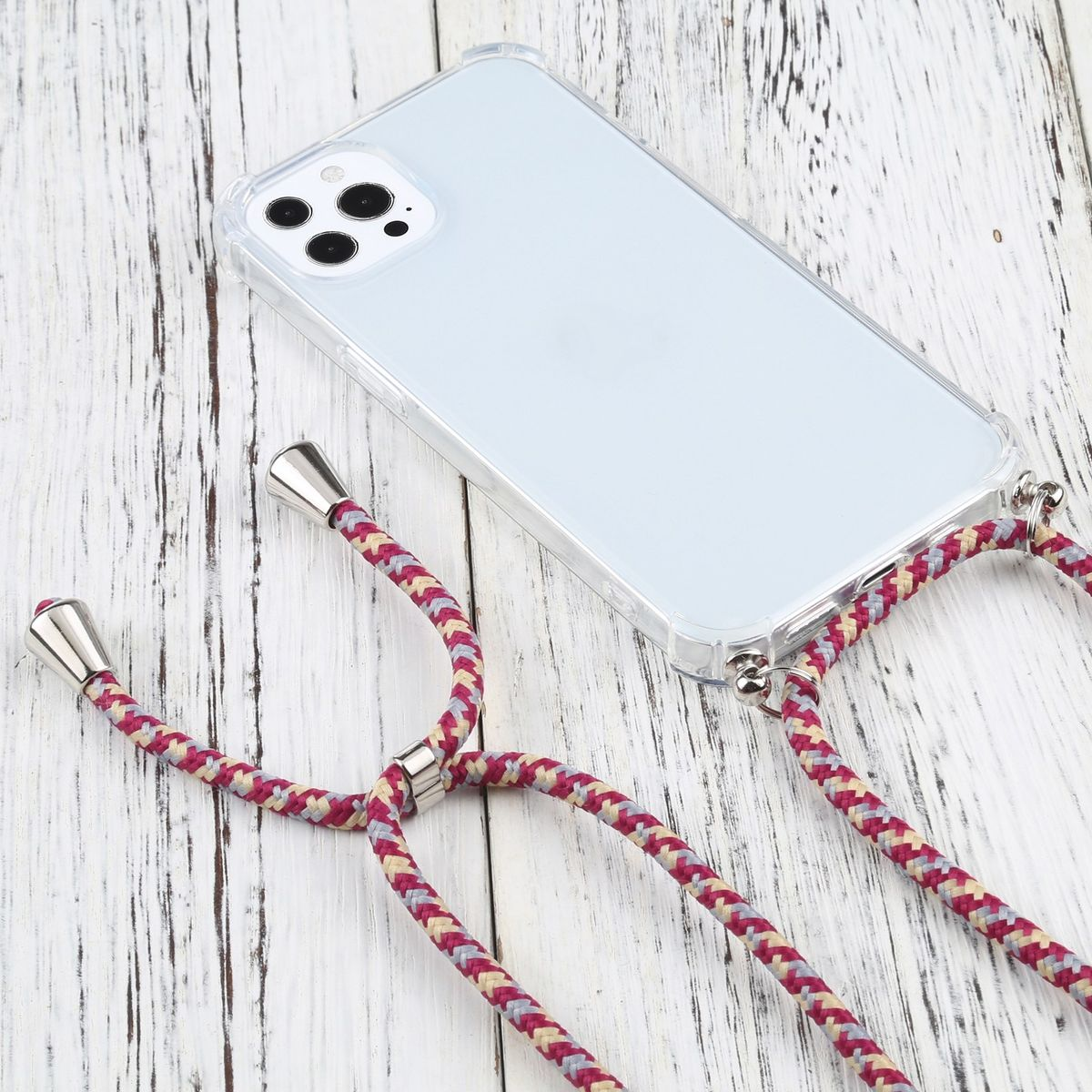 Ein Telefon in einer transparenten Hülle mit pinkfarbenem und cremefarbenem Lanyard auf einer Holzoberfläche. Das Telefon ist sichtbar.