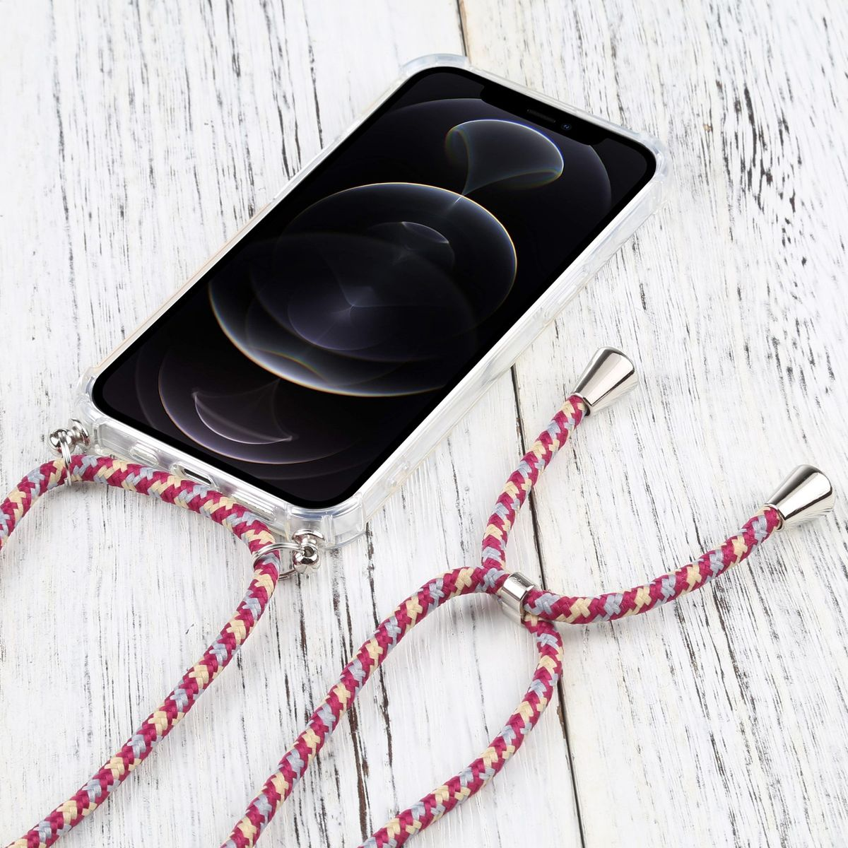 Eine transparente Handyhülle mit einem rosa und grauen Schlüsselband. Das Telefon liegt auf einer weißen Holzoberfläche.