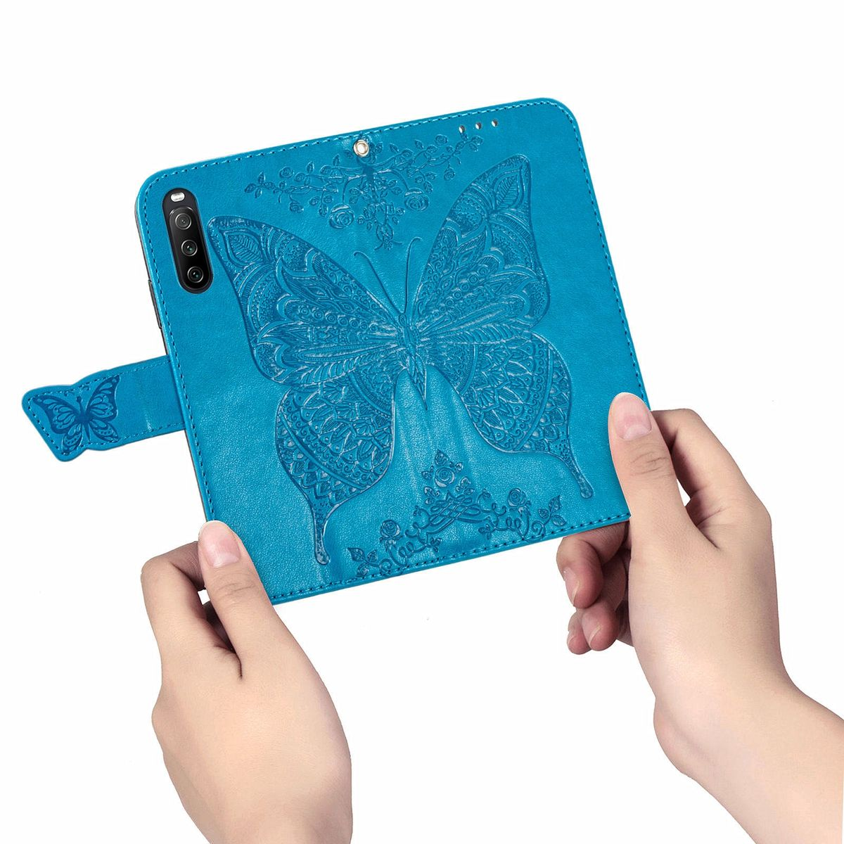 Hände halten eine blaue Handyhülle mit einem Schmetterlingsdesign. Der Schmetterling ist auf der Hülle geprägt.