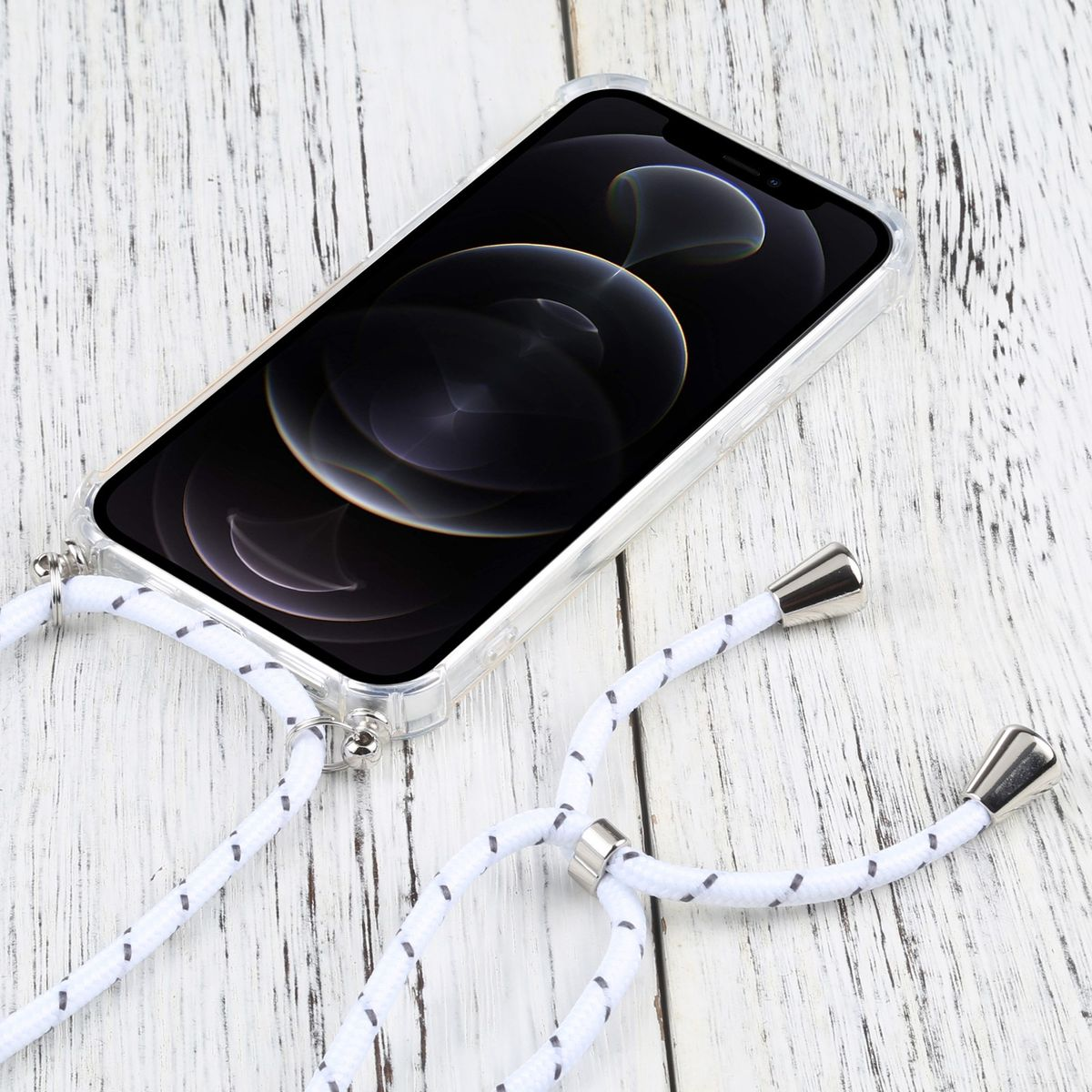 Ein Telefon wird mit einem Umhängeband gehalten. Das Telefon befindet sich in einer durchsichtigen Hülle und liegt auf einer Holzoberfläche.