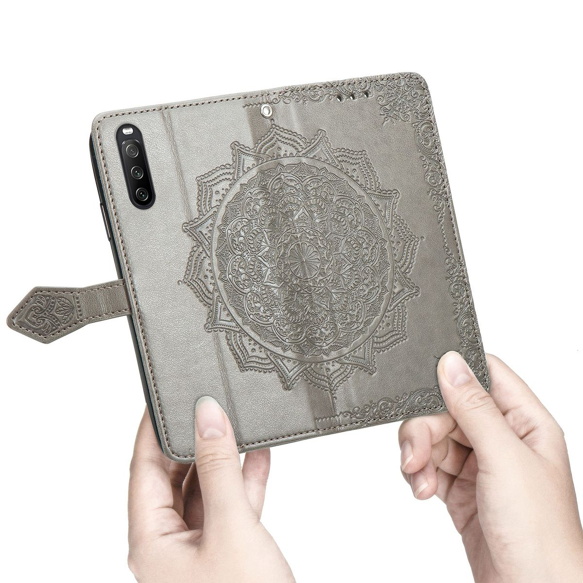 Eine Person hält eine graue Handyhülle mit einem Mandala-Design in der Mitte. Die Handyhülle ist offen.