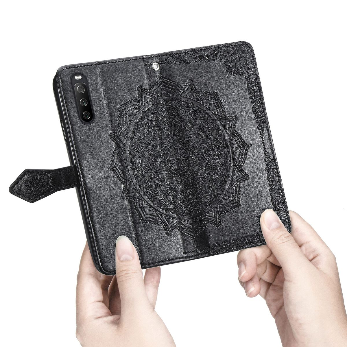 Eine schwarze Handyhülle mit Mandala-Design. Hände halten das Telefon, Cover offen.