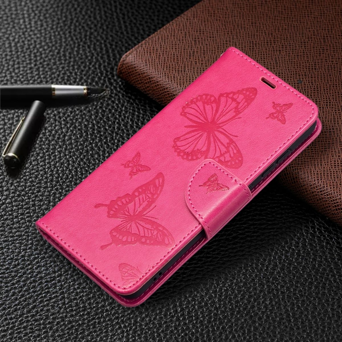 Eine pinkfarbene Handyhülle mit Schmetterlingsdesigns. Mehrere Schmetterlinge sind auf der Hülle geprägt.