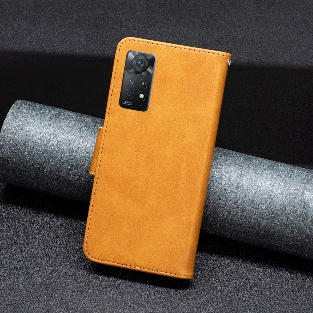 Eine orangefarbene Leder-Handyhülle mit Kameraausschnitt und geschlossenem Design. Sie liegt auf einer dunklen Oberfläche.