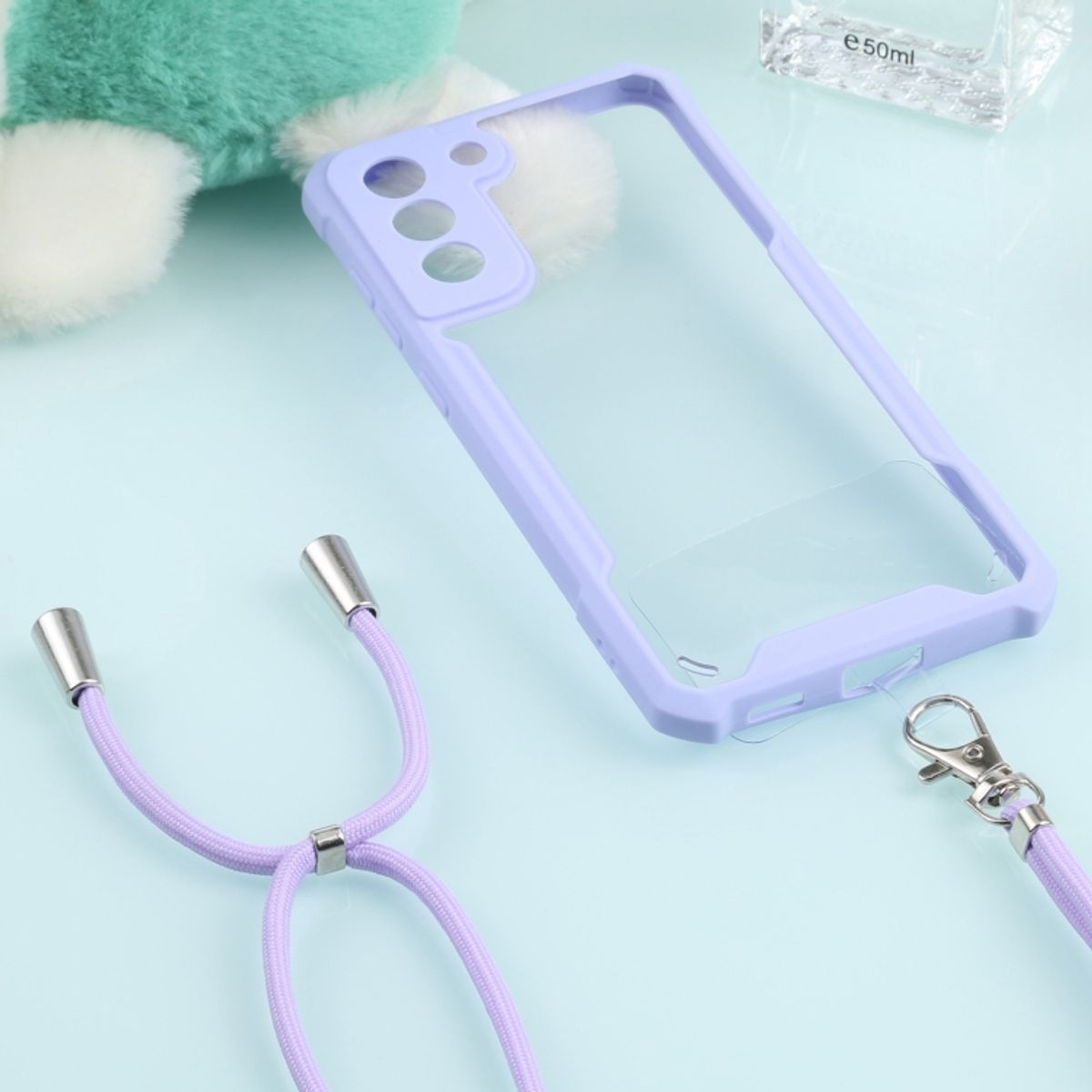 Eine transparente und lila Handyhülle mit Riemen und silbernem Verschluss und einem Telefon.