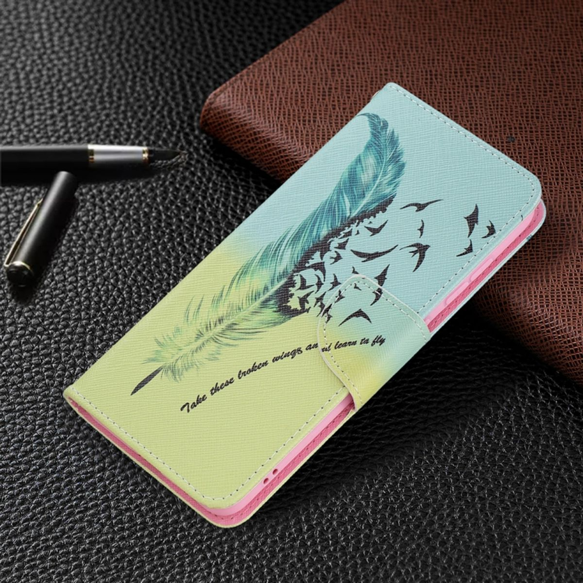Handyhülle mit Federdesign, offen, auf Lederoberfläche.