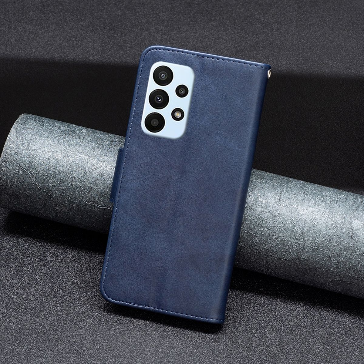 Blaue Handyhülle mit eingelegtem Telefon. Die Hülle befindet sich auf einer dunkelgrauen Oberfläche.