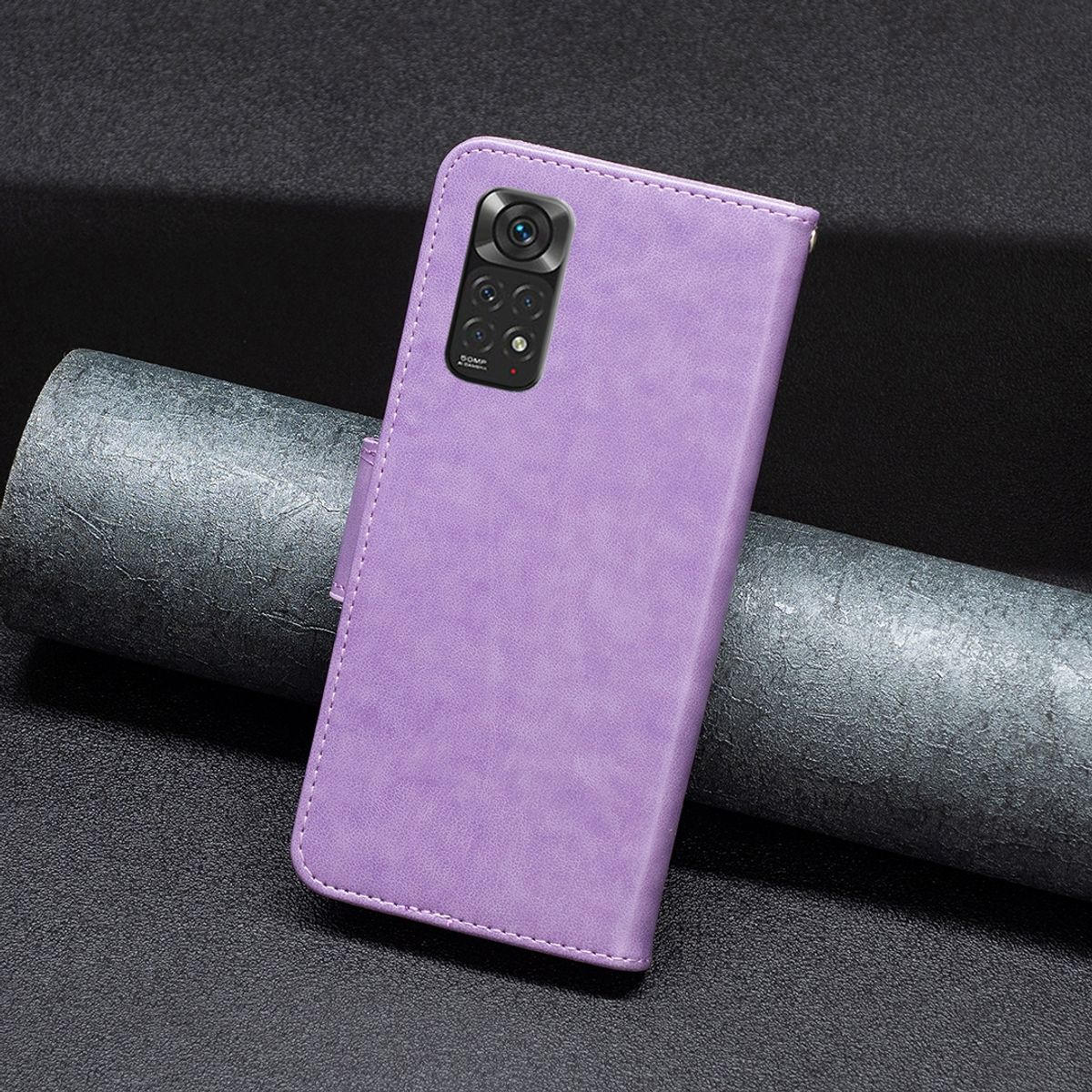 Eine geschlossene lila Leder-Handyhülle mit Telefon. Im Hintergrund eine dunkelgraue Oberfläche.