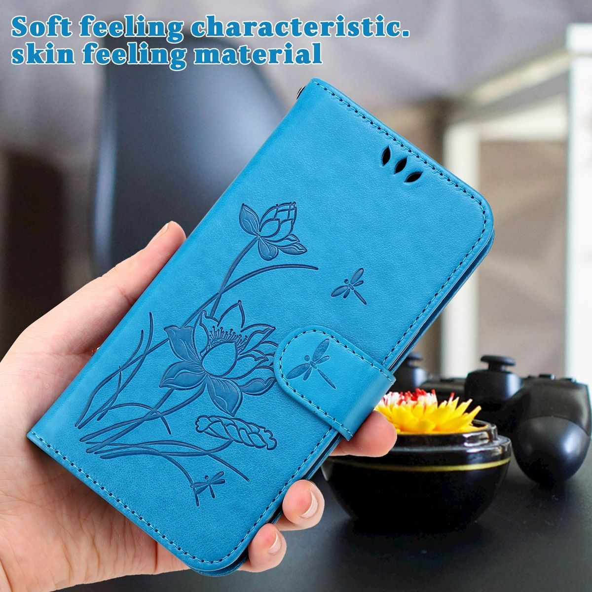Blaue Handyhülle mit Blumendesign. Hand, die die Hülle hält. Text: Weiches Gefühl.