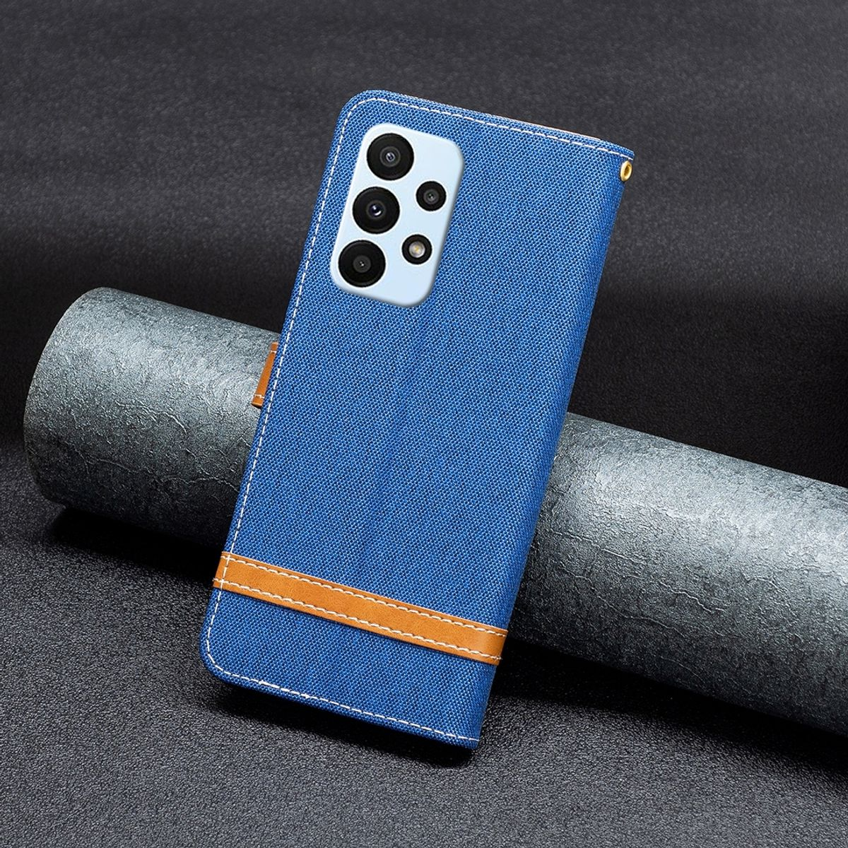 Blaue Handyhülle mit braunem Riemen auf dunklem, grauem Hintergrund. Das Telefon hat eine Kameraanordnung.