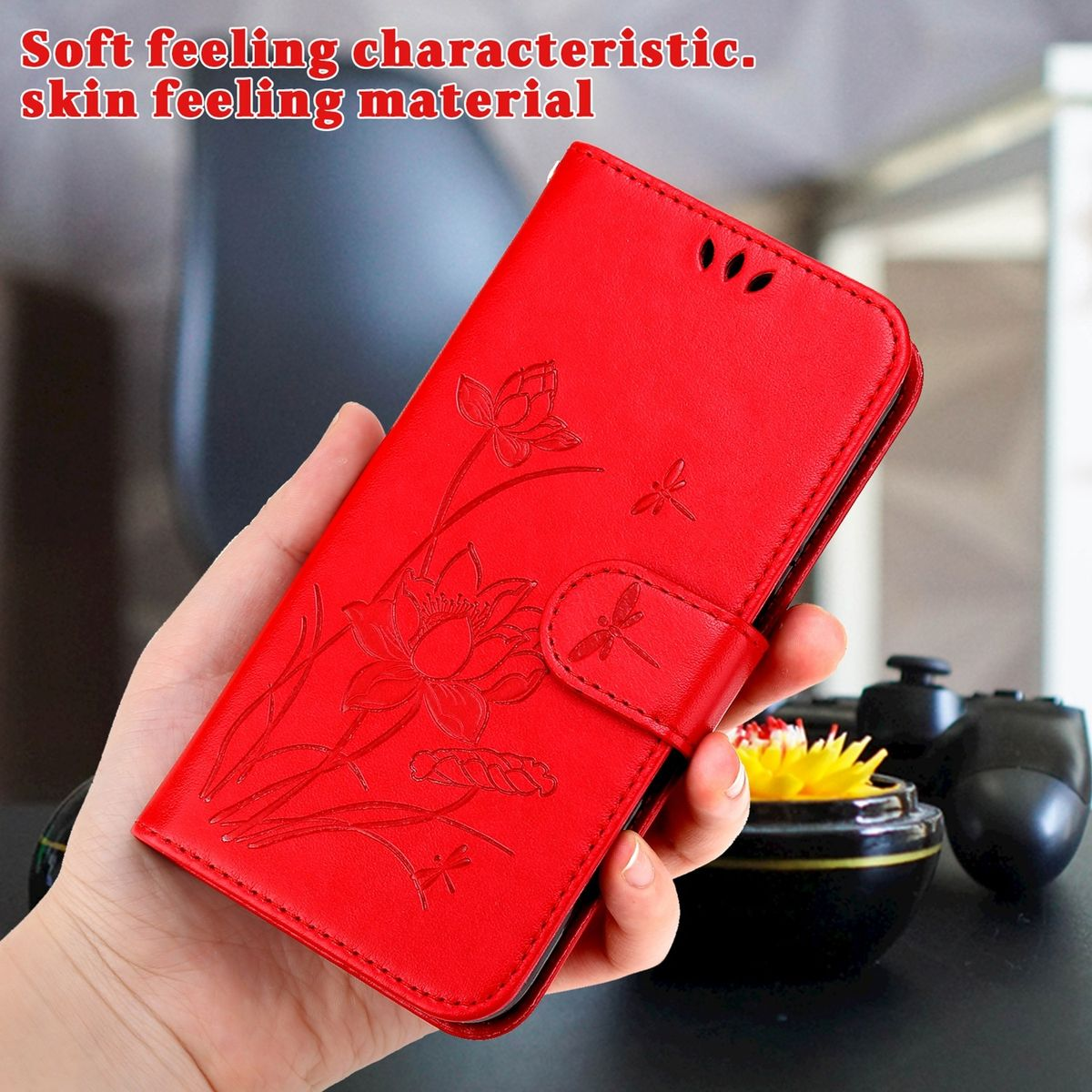 Eine rote Handyhülle mit floralem Design, eine Hand hält sie.