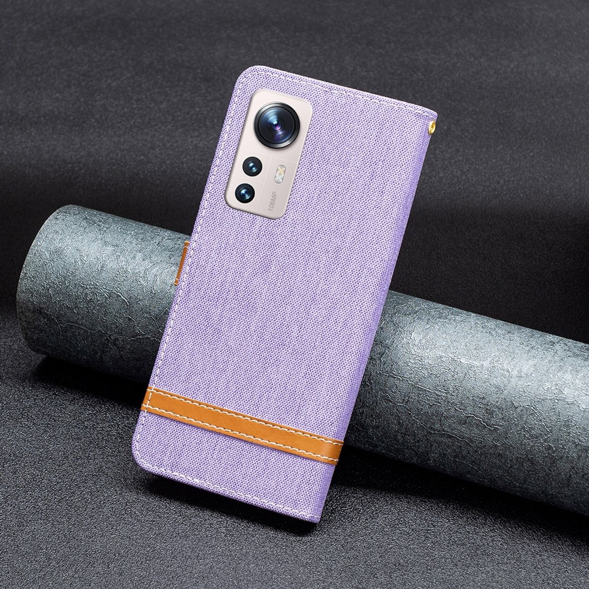 Lila Handyhülle geschlossen mit braunem Riemen. Telefonkamera sichtbar. Handyhülle auf dunkler Oberfläche.