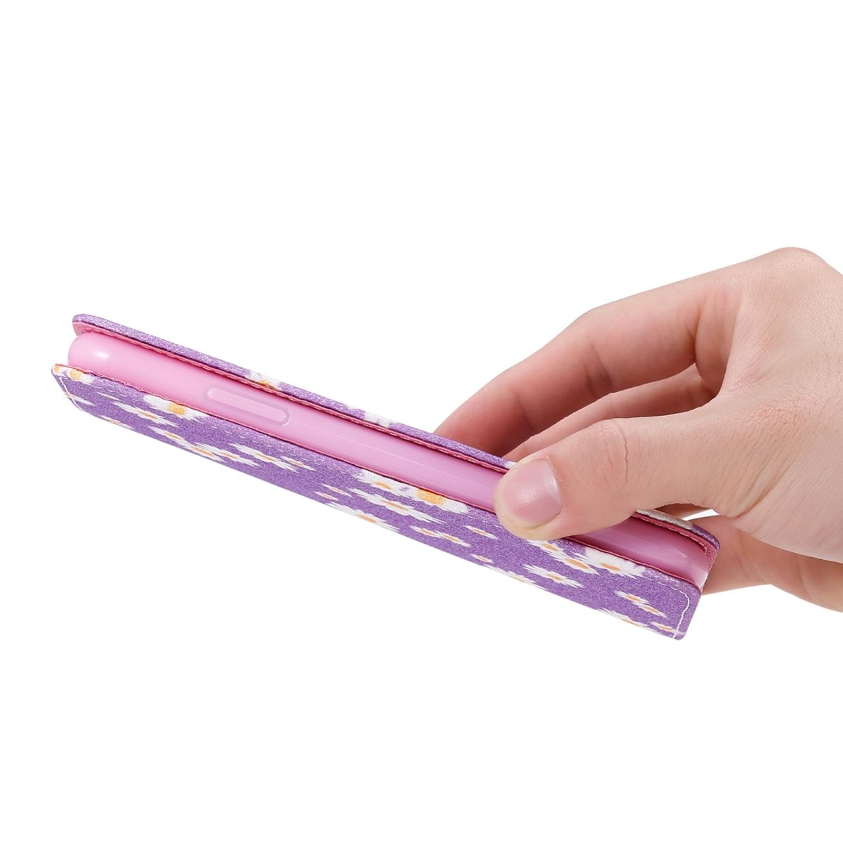 Eine Hand, die ein Telefon in einer lila Hülle mit weißem und lila Blumenmuster hält. Das Telefon liegt auf der Seite.