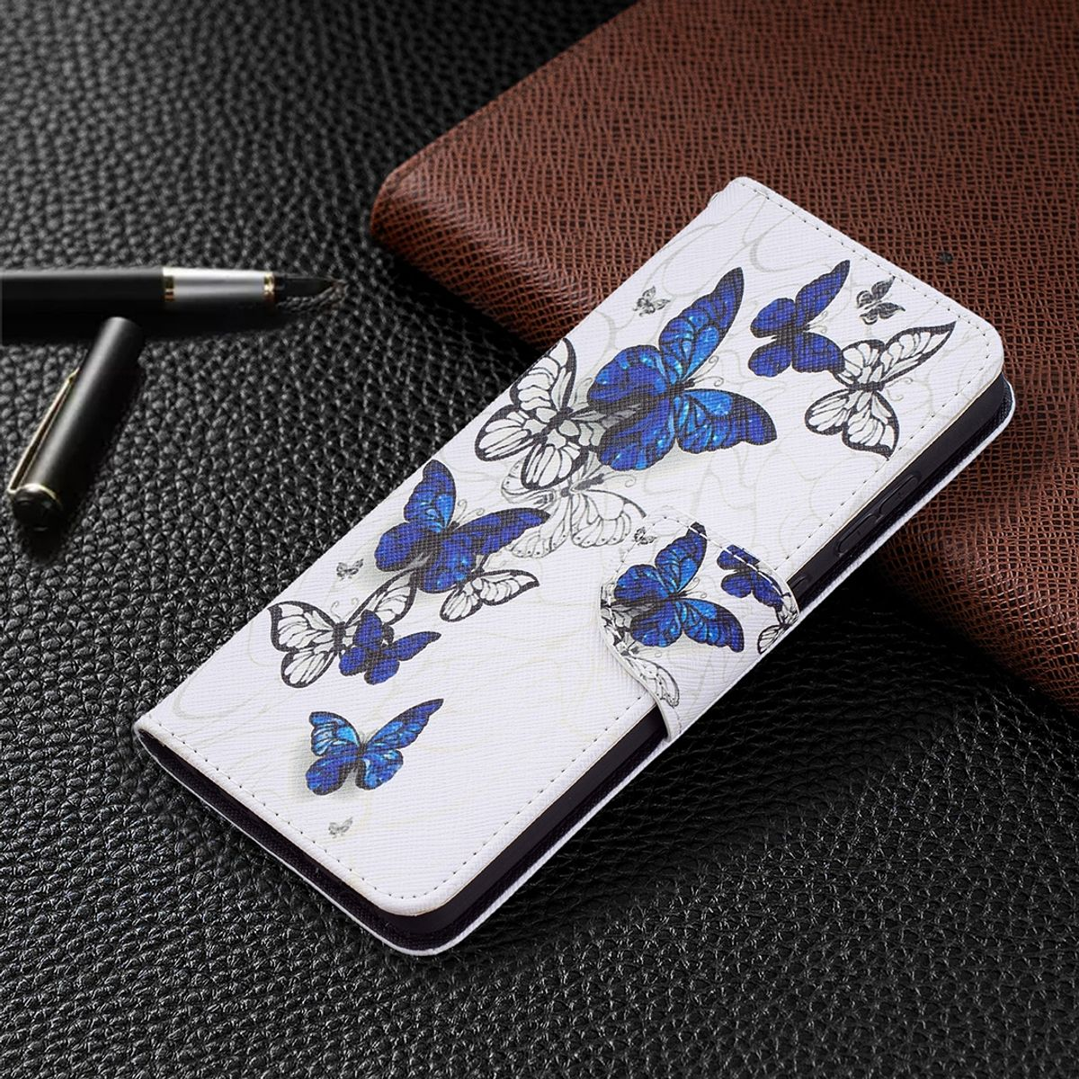 Weiße Handyhülle mit blauen Schmetterlingen. Telefon im Inneren.