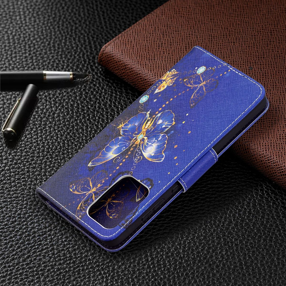 Blaue Handyhülle mit Schmetterlingsdesign. Stift und Geldbörse auf Lederoberfläche.