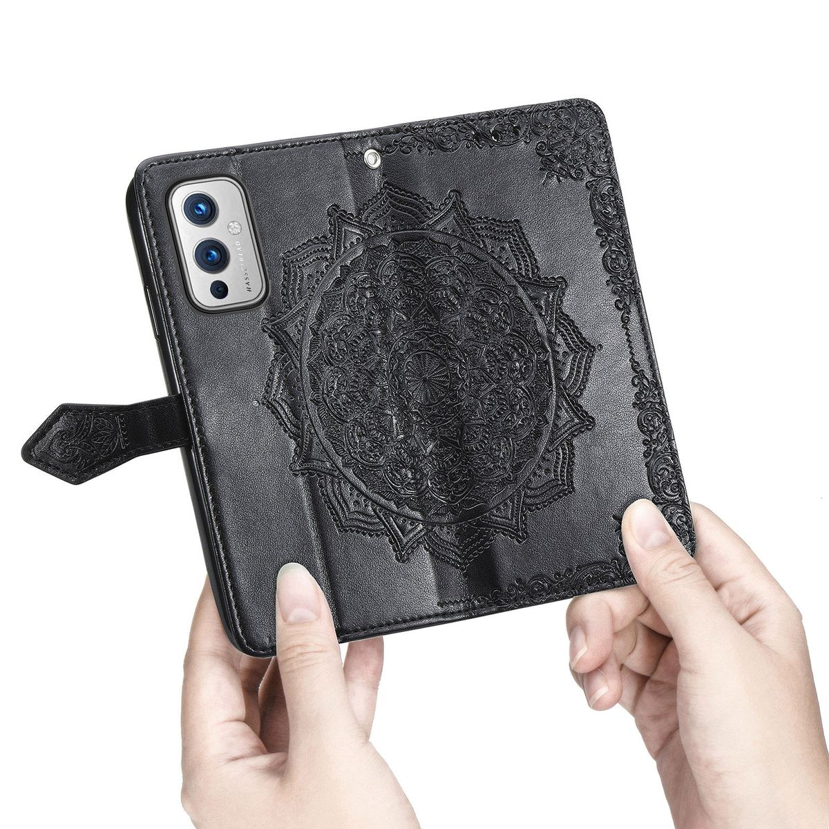 Schwarze Handyhülle mit Mandala-Design, zwei Hände halten die Hülle, weißer Hintergrund.