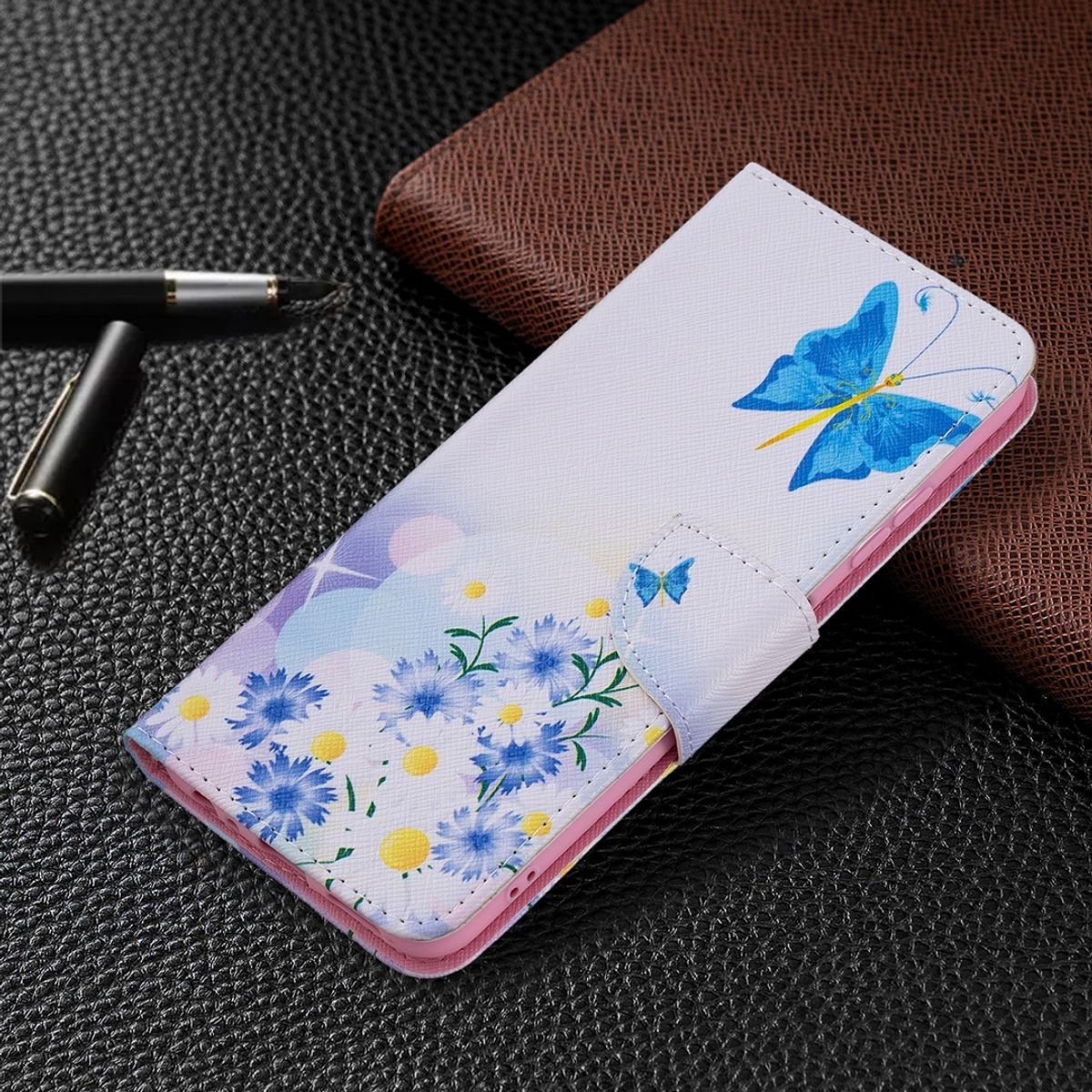 Weißes Handyhülle mit blauem Schmetterling und Blumen. Schwarzer Hintergrund.