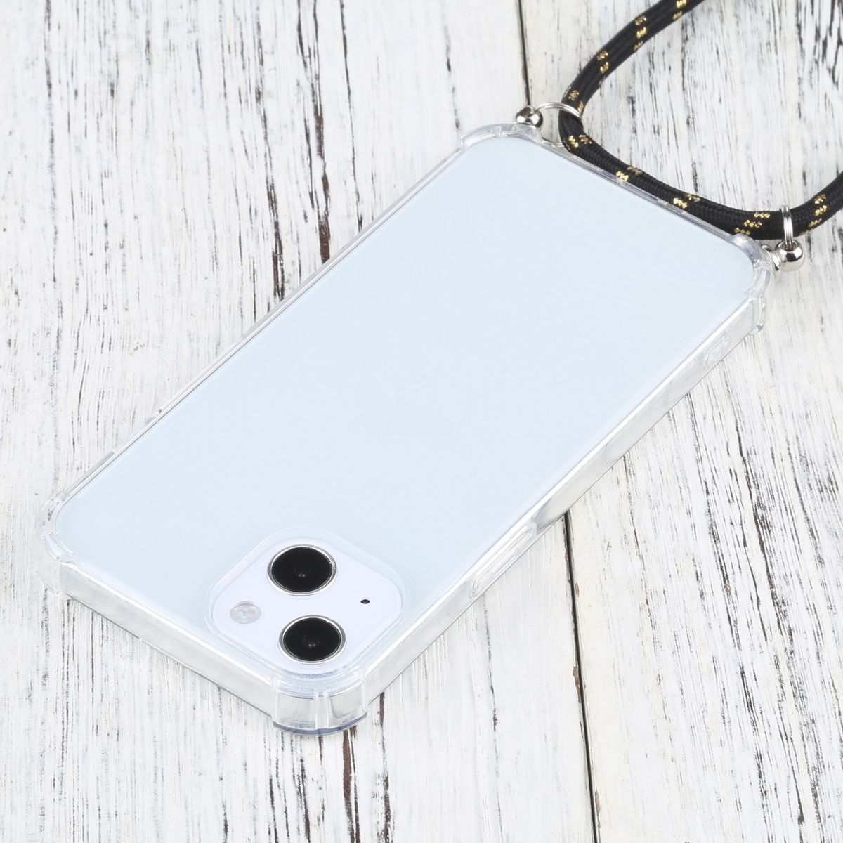 Transparente Handyhülle mit schwarz-goldener Kordel auf Holz. Telefon hat zwei Objektive.