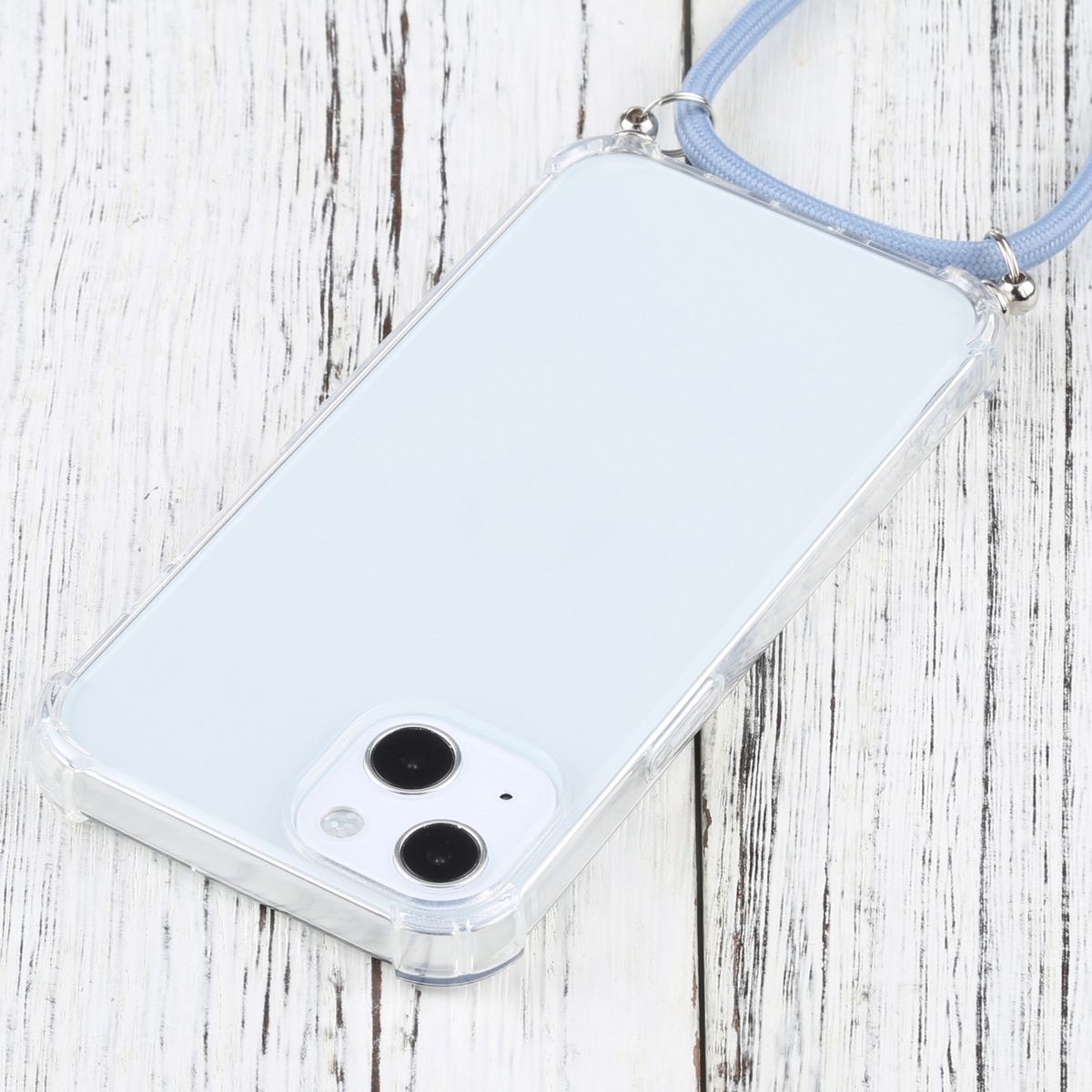 Transparente Handyhülle mit blauem Schlüsselband. Das Telefon liegt auf einer Holzoberfläche. Der Hintergrund ist Holz.