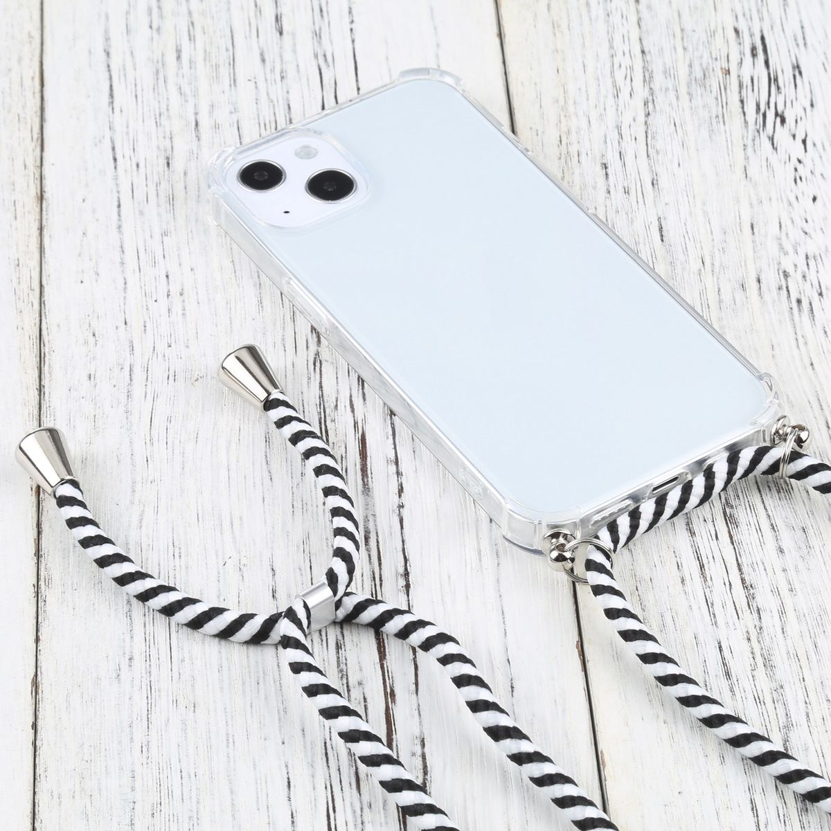 Transparente Handyhülle mit schwarz-weiß gestreiftem Riemen. Das Telefon liegt auf einer Holzoberfläche.