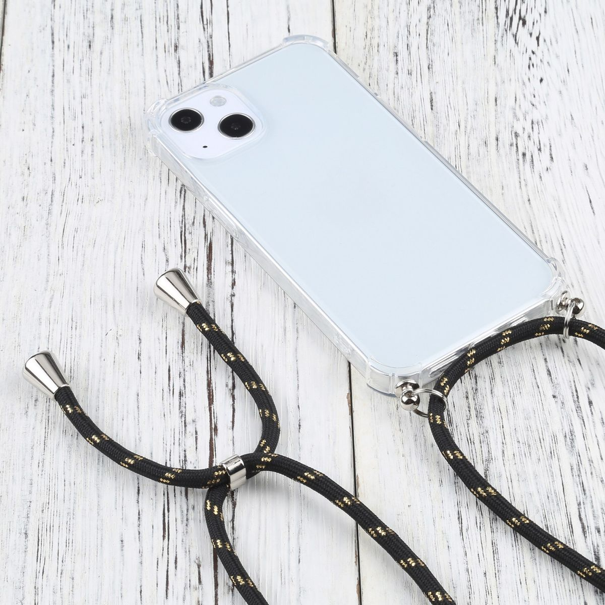 Transparente Handyhülle mit schwarzem und goldenem Lanyard. Telefon liegt auf hellem Holzgrund.