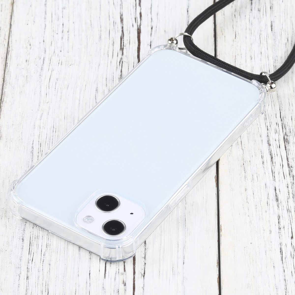 Transparente Handyhülle auf weißer Holzoberfläche mit schwarzem Riemen. Das Telefon hat zwei Kameralinsen.