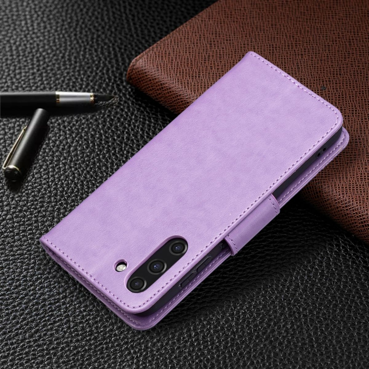 Lila Handyhülle mit Telefon, geschlossen, auf dunkler Oberfläche.