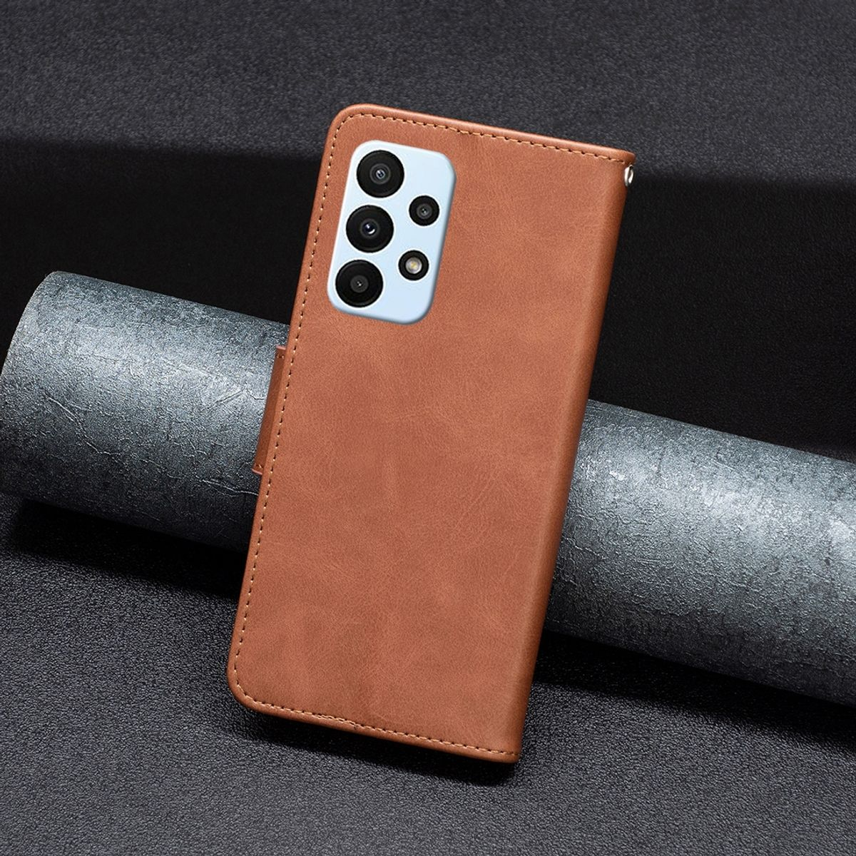 Braune Leder-Handyhülle mit Kameradesign. Es ist auf einem dunklen Hintergrund platziert.