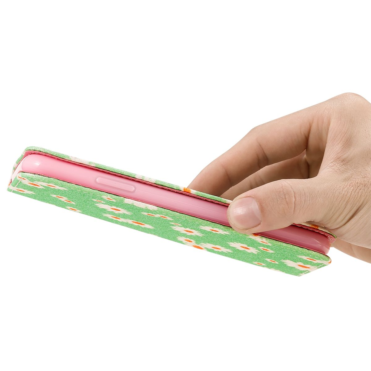 Telefon in grün-weiß gemusterter Hülle, von Hand gehalten. Das Telefon ist rosa.